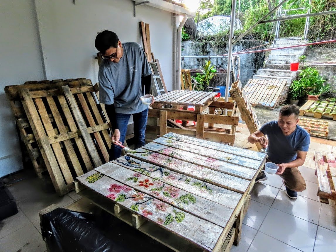 路德會社會服務處項目發展主任麥鋒慈(左)和虎地坳村居民福利會主席廖志協參與天然染料卡板繪製。(受訪者提供)